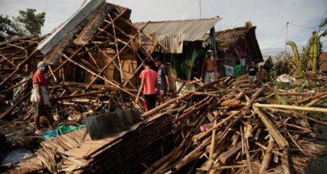 Des habitants récupèrent des affaires dans leurs maisons détruites dans la ville côtière de Dulag, dans la province de Leyte, le 17 décembre 2021, au lendemain du passage du typhon Rai.