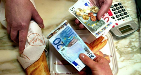 Une personne achète sa baguette de pain, le 2 janvier 2002, dans une boulangerie de Lille, avec un billet de 20 euros. 