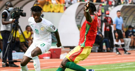 Le défenseur sénagalais Ibrahima Mbaye (g), à la lutte avec le défenseur guinéen Issiaga Sylla, lors de leur match du groupe B de la Coupe d'Afrique des nations, le 14 janvier 2022 à Bafoussam (Cameroun).