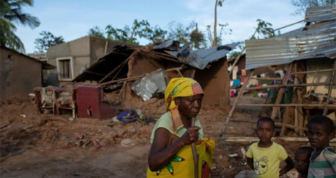 Une famille devant des maisons détruites par le cyclone Gombe à Nampula, le 13 mars 2022.