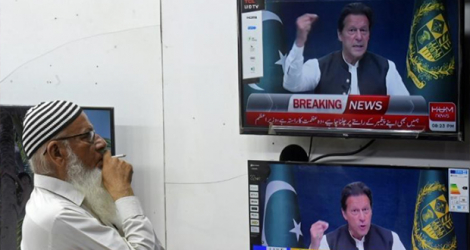 Un habitant de Karachi écoute un discours télévisé du Premier ministre pakistanais Imran Khan, le 31 mars 2022.