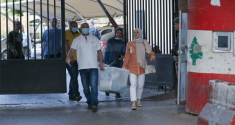 Des fonctionnaires libanais transportant des urnes scellées vers un bureau de vote à Sidon, dans le sud du pays, le 14 mai 2022.