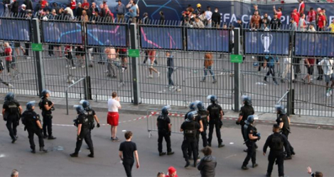 Des policiers en position près des barrières entourant le Stade de France pour empêcher des tentatives d'intrusion d'individus sans billet, lors de la finale de Ligue des champions, le 28 mai 2022 à Saint-Denis, au nord de Paris.