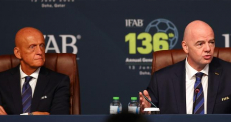 Le président de la FIFA Gianni Infantino s'exprime lors de la 136e assemblée générale annuelle de l'Ifab (International Board), le 13 juin 2022 à Doha, au côté de l'Italien Pierluigi Collina, président de la Commission des Arbitres de la Fifa.