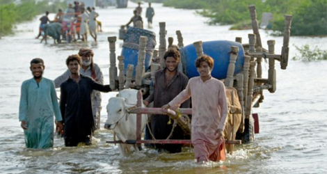 Des familles fuient avec leurs affaires après avoir évacué leurs maisons inondées, dans la province du Baloutchistan (sud-ouest), le 28 août 2022.