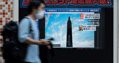 Un homme passe devant un écran de télévision montrant le lancement d'un missile nord-coréen, à Tokyo, le 4 octobre 2022.