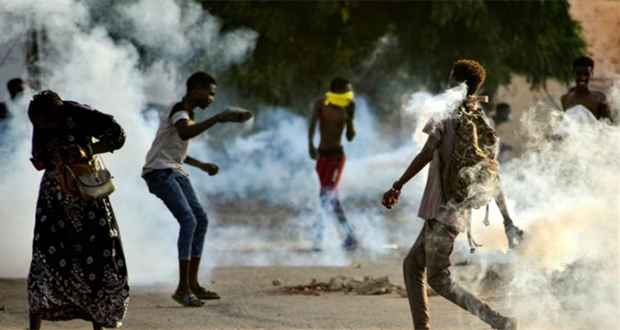 Des jeunes soudanais affrontent les forces de sécurité au milieu de gaz lacrymogènes tirés pour disperser les manifestants dans la capitale Khartoum, le 27 octobre 2021.