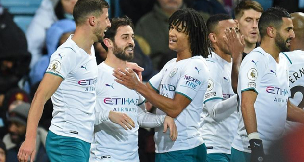 La joie du milieu de terrain portugais de Manchester City, Bernardo Silva (2e g), félicité par ses coéquipiers, après avoir marqué le 2e but face à Aston Villa, lors de la 14e journée de Premier League, le 4 décembre 2021 au Villa Park à Birmingham.