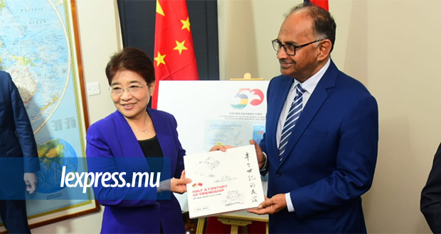 L’ambassadrice Xu Jinghu recevant un livre des mains du ministre Alan Ganoo.  © Vashish Sookrah