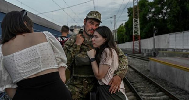 Un soldat ukrainien étreint sa compagne avant de prendre le train pour Dnipro, le 24 juillet 2022 à la gare d'Odessa.